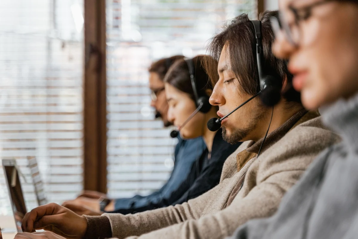 Agentes de atención al cliente atendiendo llamadas con auriculares