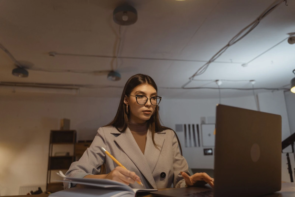 Comercial analizando perfiles profesionales en el portátil y tomando notas