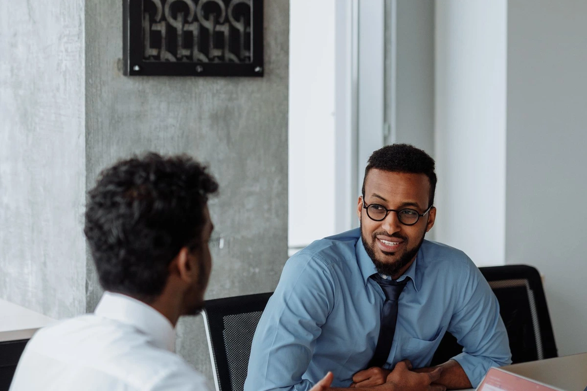 Responsable de ventas conversando de forma individual con un comercial de su equipo.