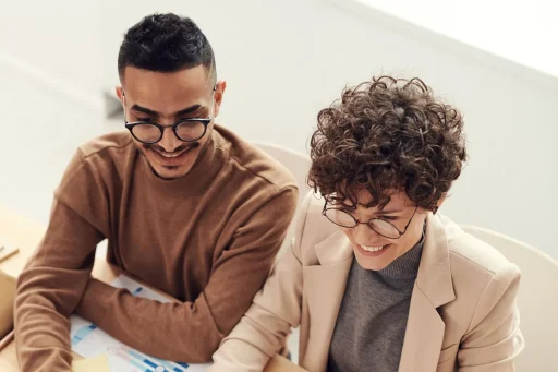 Dos profesionales analizan graficos de resultados de ventas en una reunion