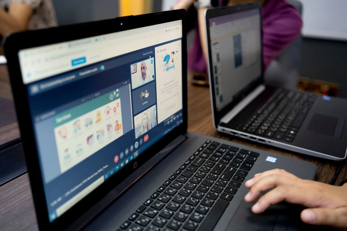 Videollamada de trabajo con varios participantes conectados en la pantalla de un portátil